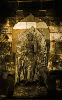 Statue of buddha against wall of building