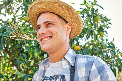 Portrait of young man looking away against plants