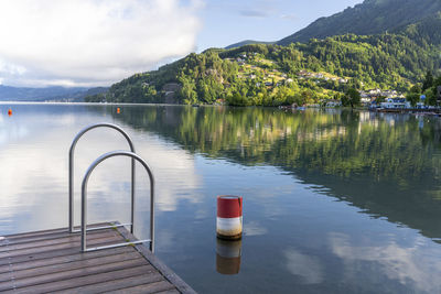 Scenic view over millstätter lake from a beach with jetty to mountains