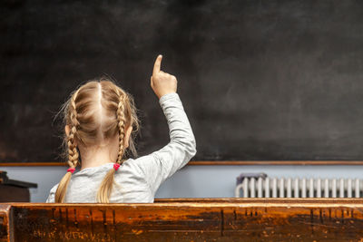 Portrait of girl with arms raised in background