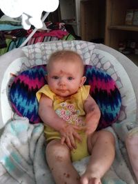 Portrait of cute baby girl lying on bed