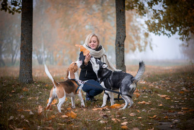 Full length of woman with dog on street during autumn