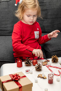 Christmas kids craft activities at home. little child painting pine cones and  decorations