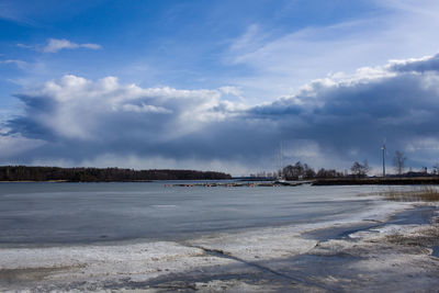 View of frozen lake against cloudy sky