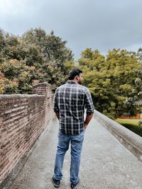 Rear view of man standing against the wall