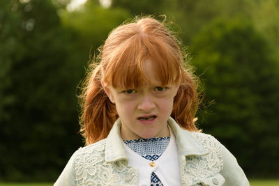 Portrait of angry girl standing at park