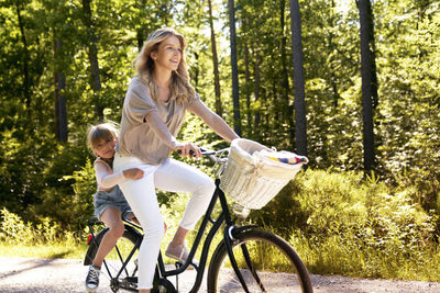 Mother riding bicycle with daughter