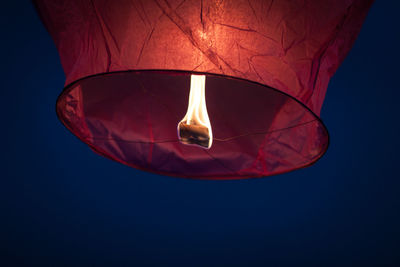 Low angle view of lit sky lantern at night