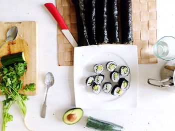 Directly above shot of sushi and vegetables on table