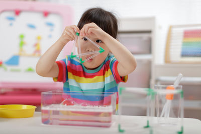 Young girl playing science experiment at home 