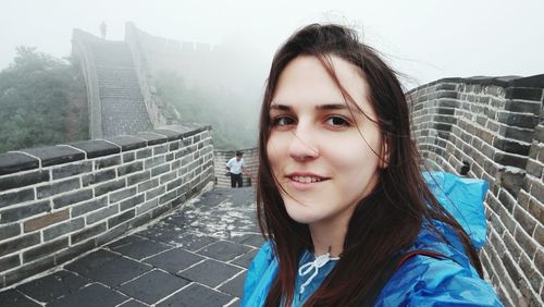 Portrait of smiling young woman at great wall of china