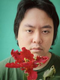 Close-up portrait of woman with red flower