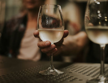 Close-up of hand holding wineglass at table