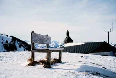 Built structure on snow covered field by building against sky