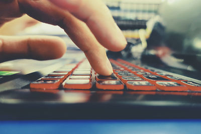 Cropped hand of person using laptop