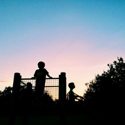 Silhouette men playing on field against sky during sunset