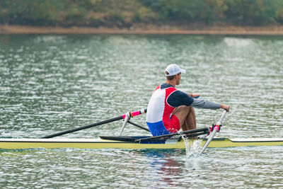 Rear view of men in boat on lake