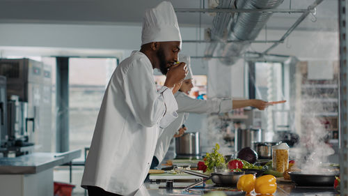 Chef smelling food in kitchen