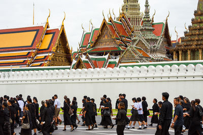 People at temple against sky