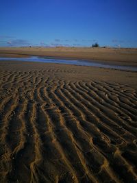 Scenic view of beach against clear blue sky