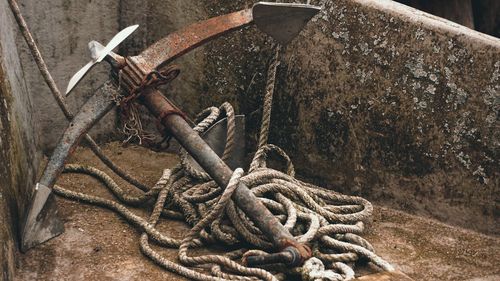 Close-up of rope tied on rusty metal chain