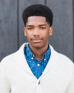 Portrait of young man standing against wall