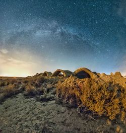 Rock formation on landscape against sky at night