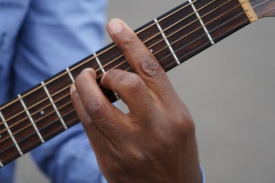 Midsection of man playing guitar