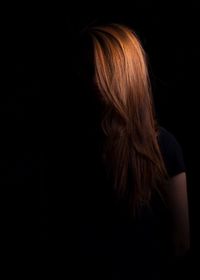 Rear view of woman against black background
