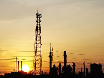 Low angle view of silhouette electricity pylon against sky during sunset