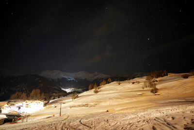 Scenic view of snowcapped mountains against sky at night