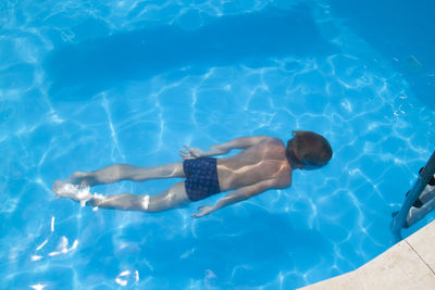 High angle view of boy swimming in pool