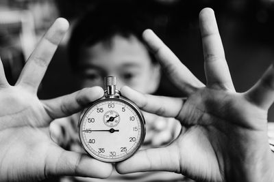 Close-up of boy holding stopwatch