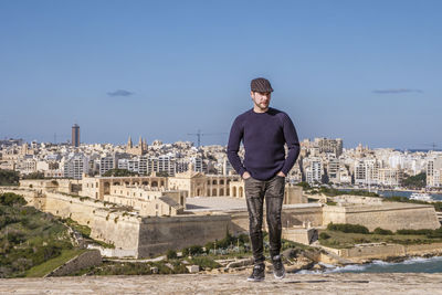 Portrait of man standing against cityscape