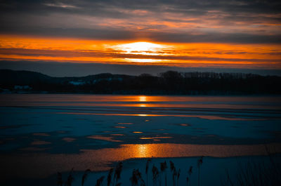 Scenic view of lake against orange sky