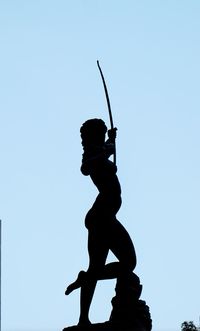 Low angle view of silhouette woman against clear blue sky