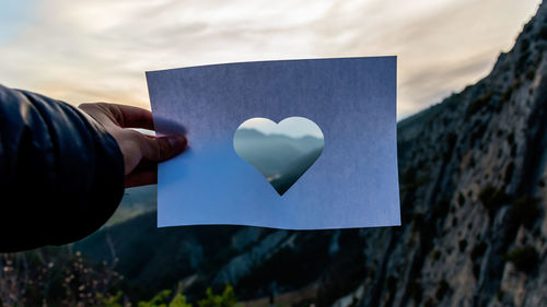 Close-up of hand holding heart shape paper