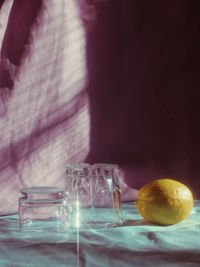 Close-up of glasses and lemon on tablecloth