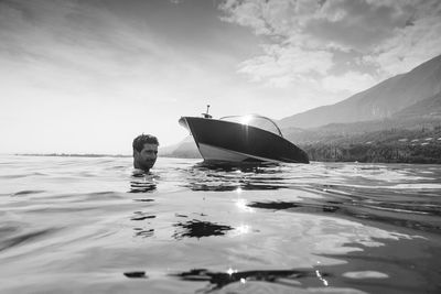 Man swimming in sea against sky