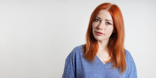 Portrait of young woman against white background