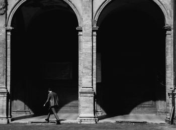 Rear view of man entering in historic building