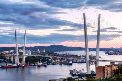 Bridge over river in city against sky