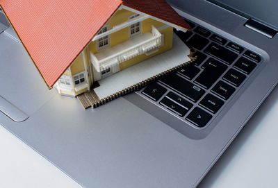 High angle view of model house on laptop keyboard
