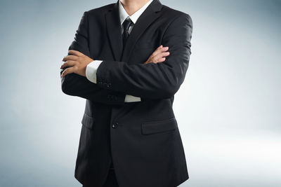Midsection of man standing against white background
