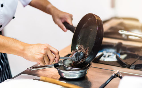 Midsection of man preparing food in kitchen