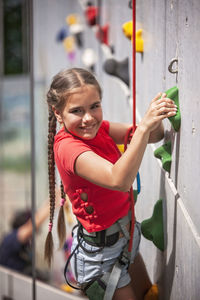 Side view of young woman standing by railing