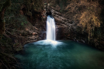 Waterfalls from above through a hole in the rock. the waterfall feeds the aniene river forming.