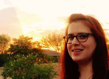 Portrait of smiling young woman against sky during sunset