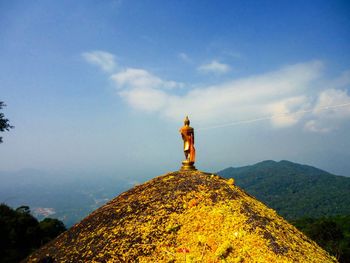 Low angle view of cross on mountain against sky