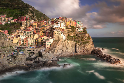 Scenic view of town by sea against sky